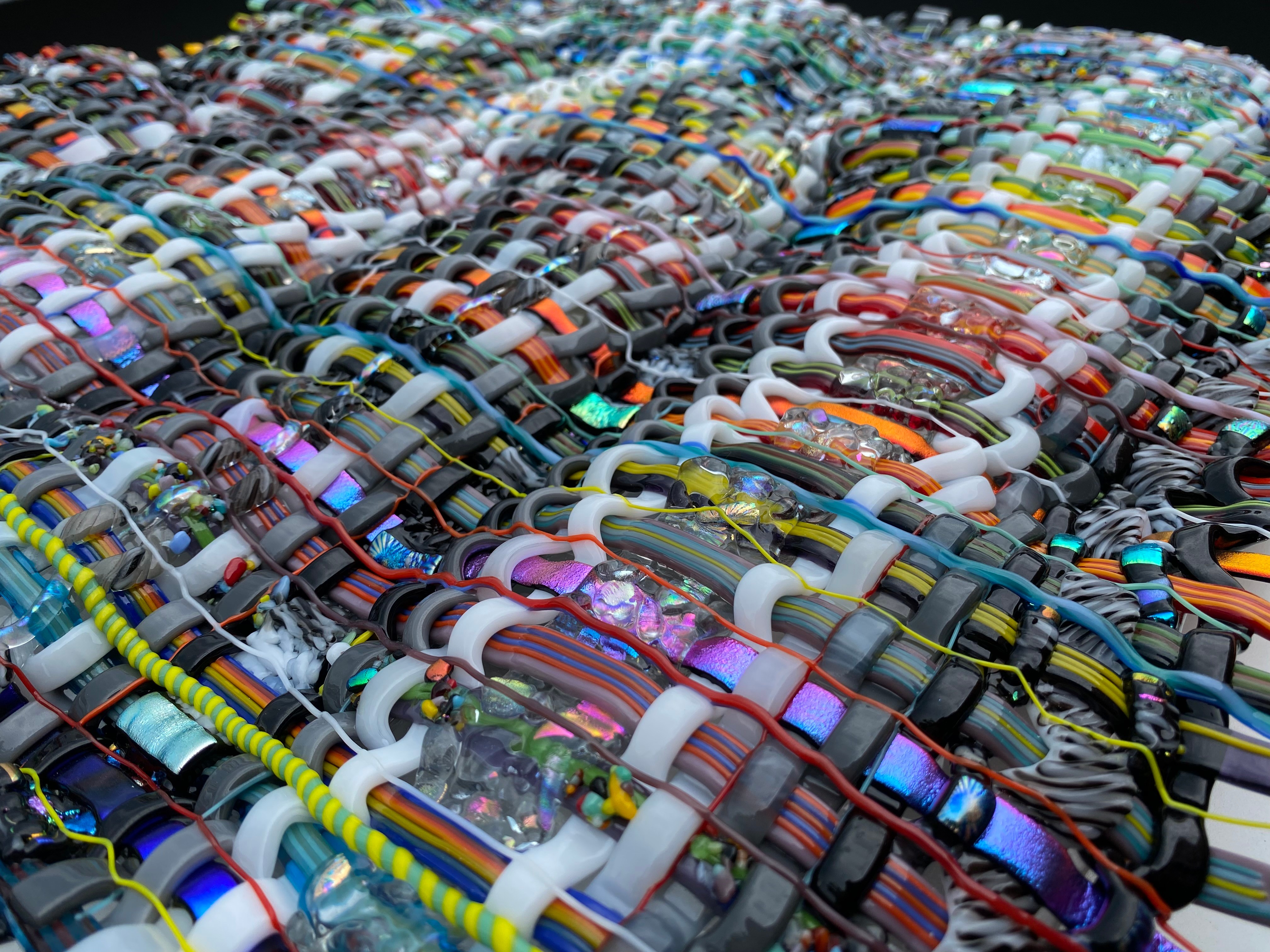 A large collection of colorful wristbands arranged in rows, overlapping each other, with various patterns and colors.