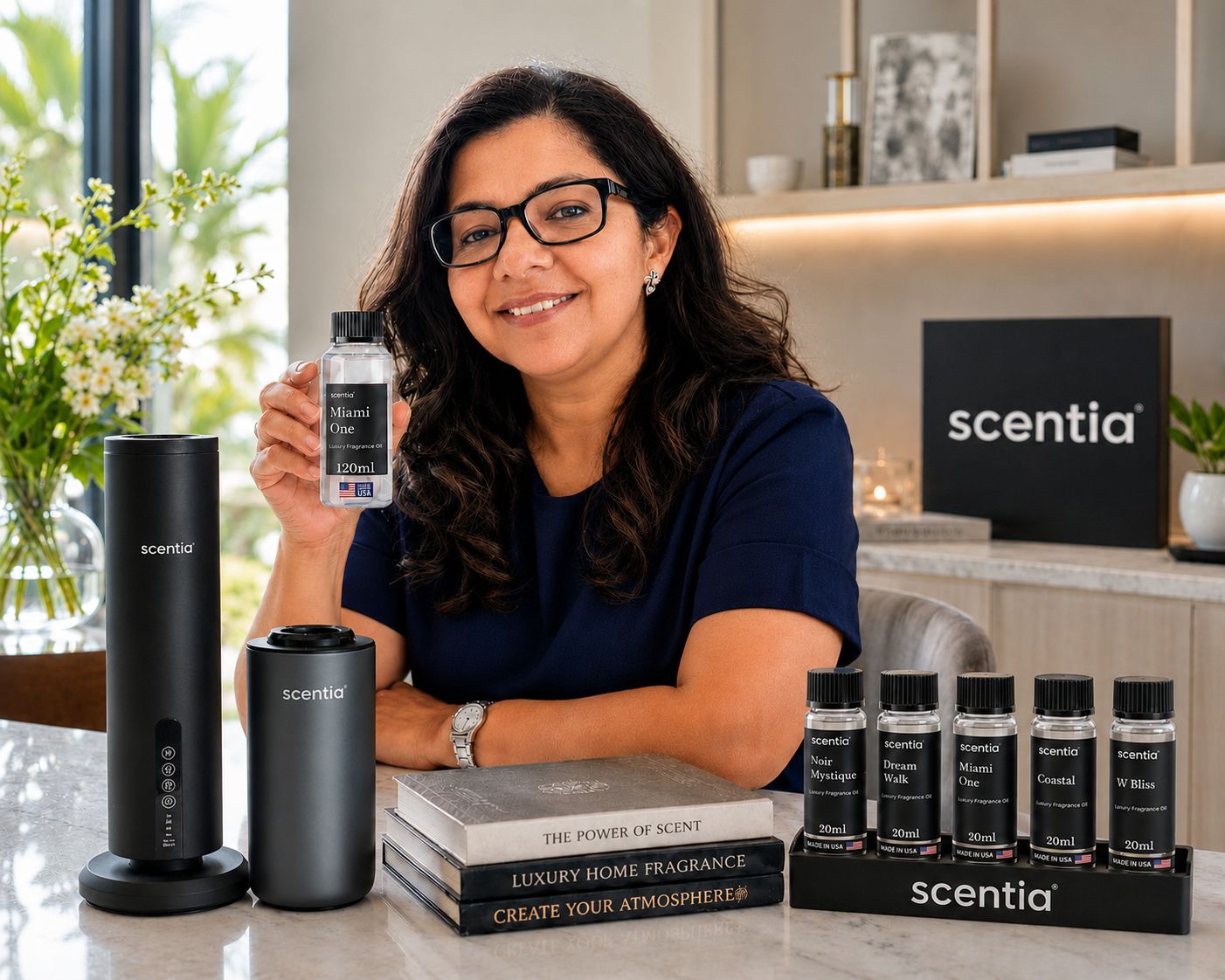 Woman with glasses smiling at a counter with scent products, books, and a black scentia sign in background.