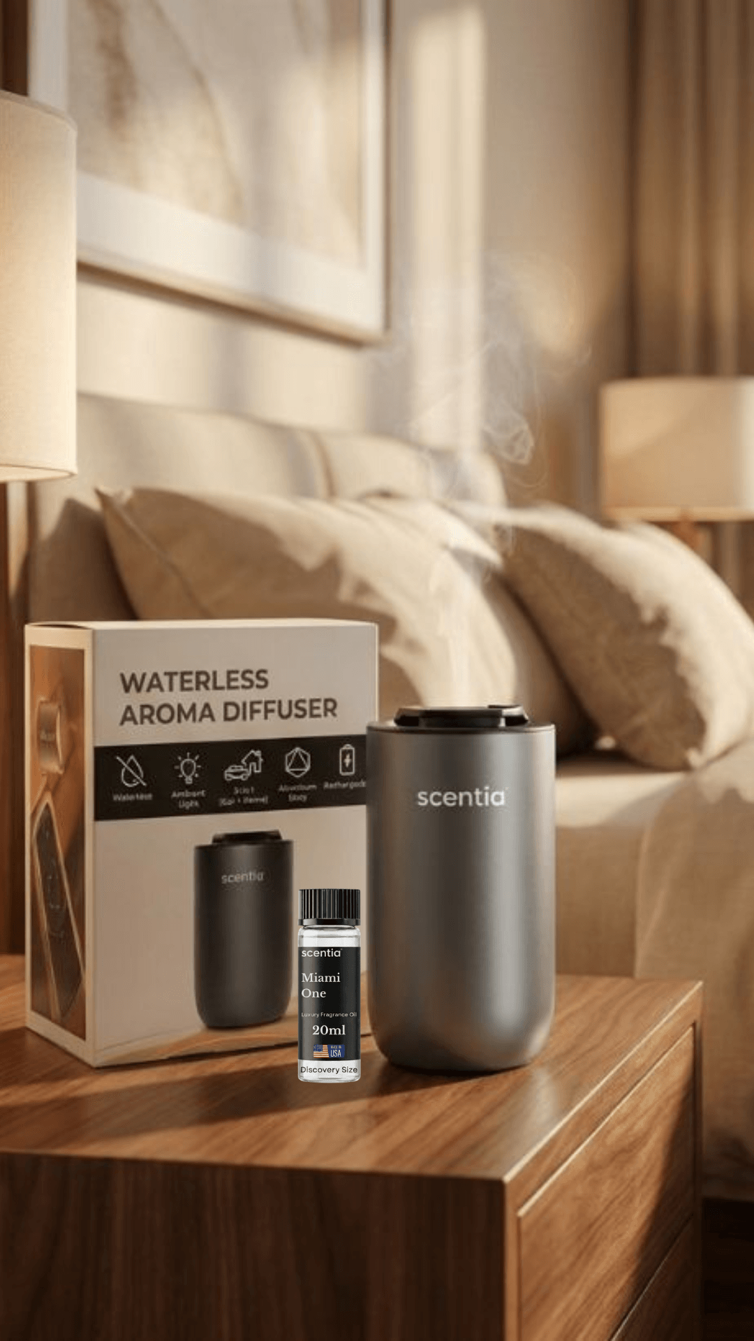 A waterless aroma diffuser on a wooden table in a bedroom, with a box and small bottle nearby, bed and lamps in background.