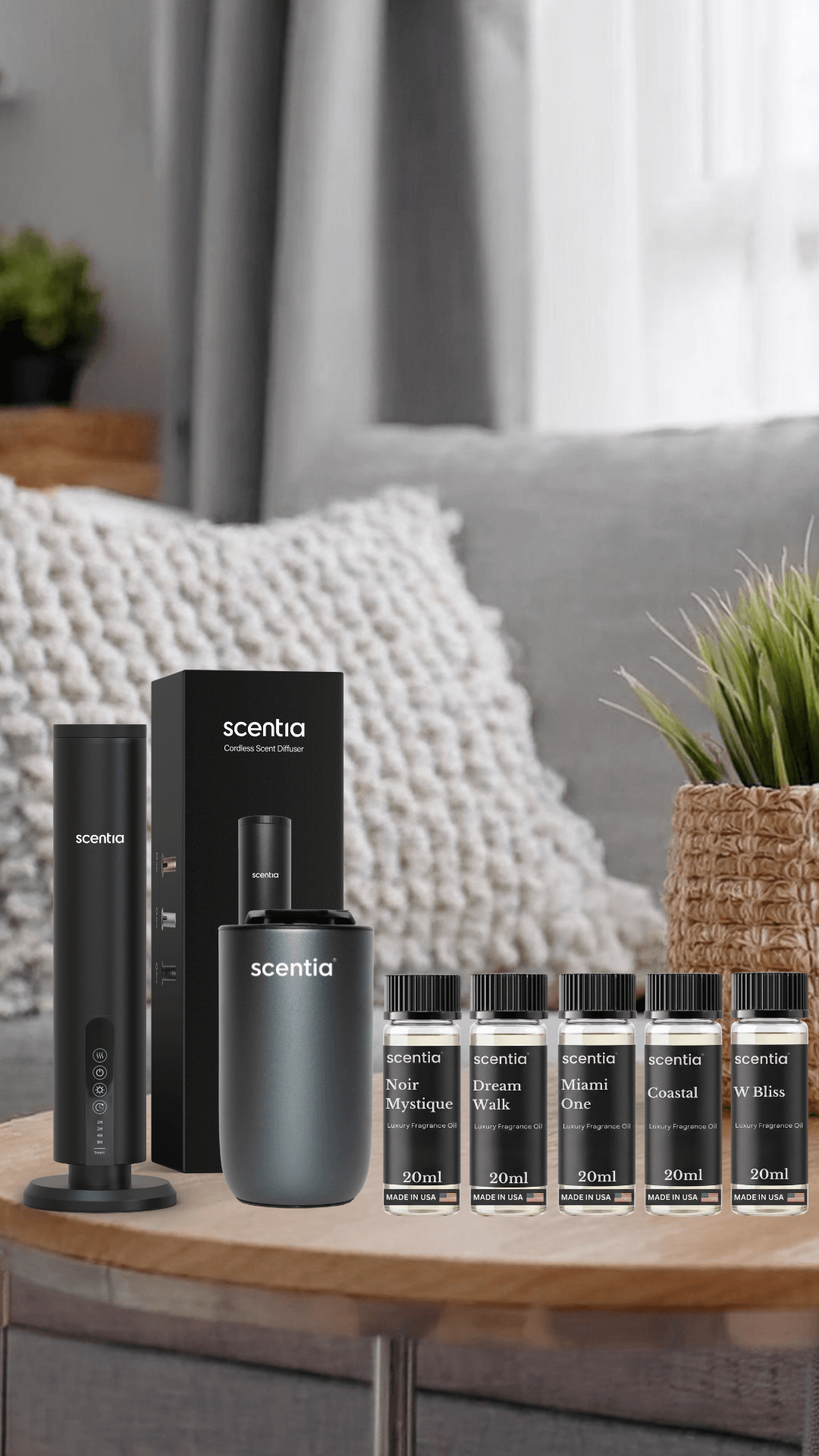 A black electronic device and six small bottles on a wooden table in a cozy living room with cushions and plants.